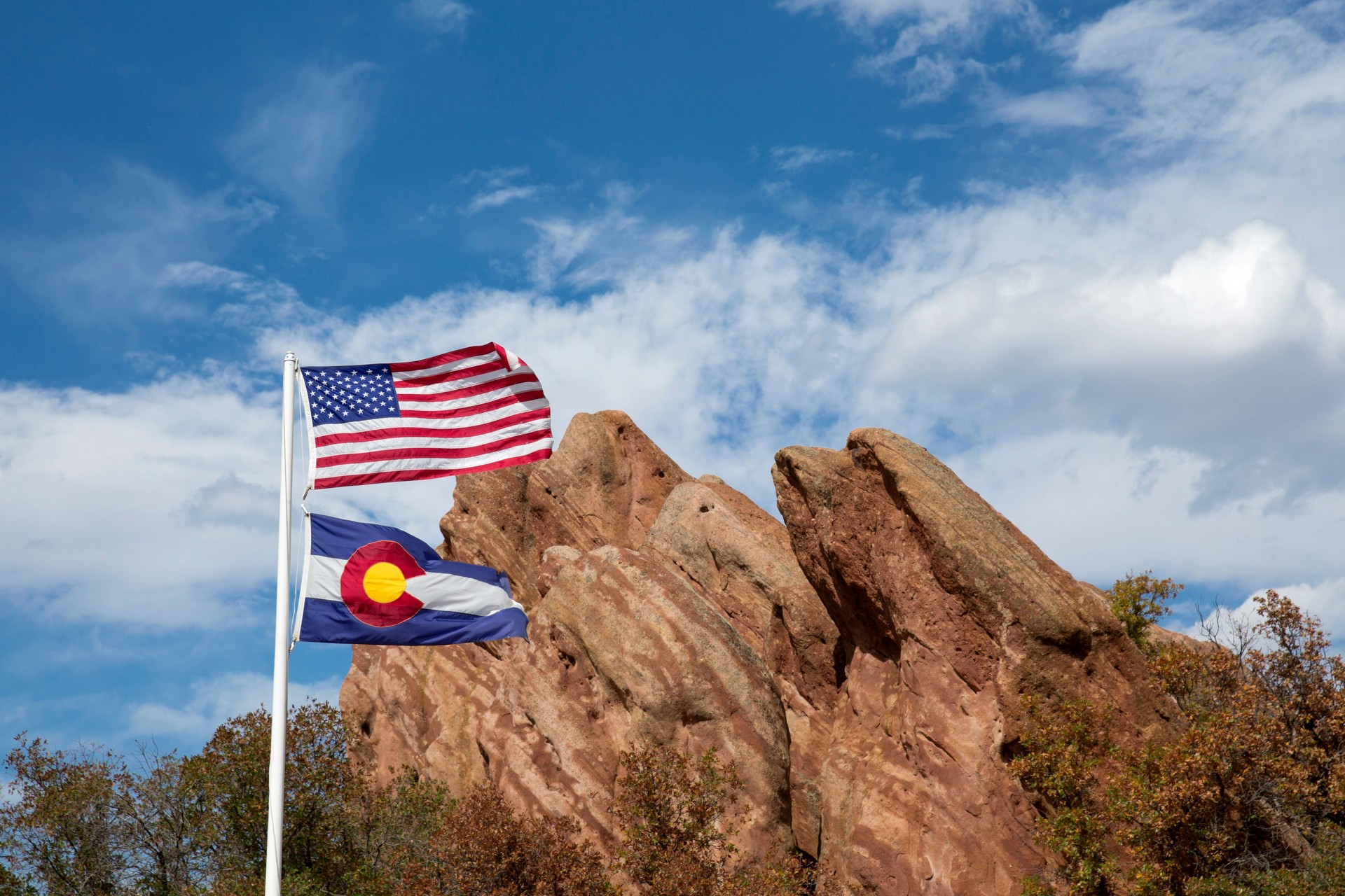 US flag in front of red rock formation at Roxborough State Park in Colorado